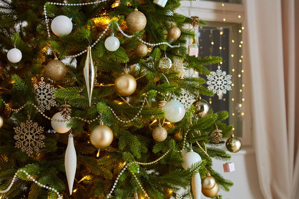 Jõulupuu kuldse, hõbedase ja valge kaunistusega.
