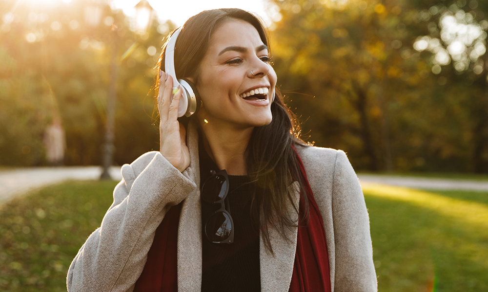 Frau hört Musik beim Spaziergang im Park