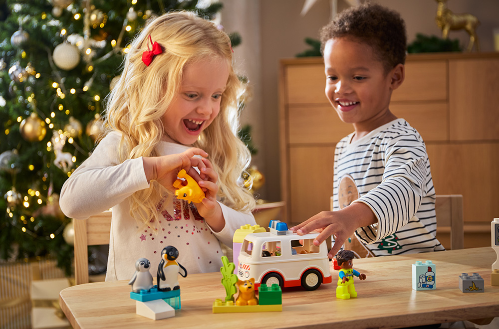 Kaks last mängivad LEGO klotsidega kuuse all.